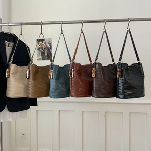 Close-up showing six vibrant colors of woven bucket bags with decorative wooden beads
