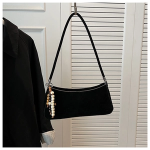 Detail view of black vintage underarm bag featuring decorative wooden bead charms