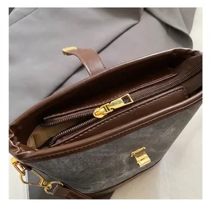 Close-up of retro bucket bag showing dark brown leather, grey fabric, and gold hardware