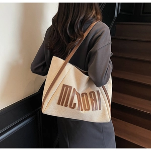 Détail du grand sac cabas en toile beige avec lanières en cuir marron et lettrage MCROAI