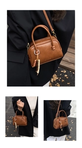 Vue détaillée du sac Boston marron avec sa texture rétro et son charm en perles