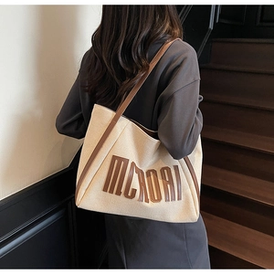 Grand sac cabas en toile avec poignées en cuir marron et lettrage MOROI en situation