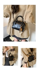 Détail du mini sac carré noir brillant avec pompon en perles de bois et texture cuir