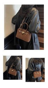 Détail du sac cabas en daim marron avec serrure dorée et bandoulière en cuir ajustable