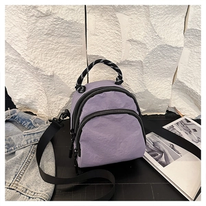 Detail of lavender mini shell backpack with textured pleats and woven handle