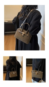 Détail du sac cabas en daim vert olive avec serrure dorée et bandoulière réglable