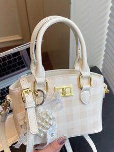Beige checkered crossbody handbag with pearl heart pendant and golden twist lock