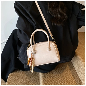 Sac à main carré beige chic avec doubles poignées et accessoire décoratif en perles de bois
