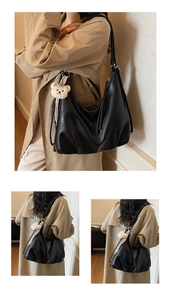 Detail of black large hobo bag featuring matte PU leather and a cute bear pendant charm