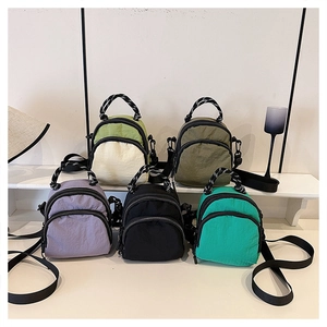 Collection of colorful mini nylon crossbody bags with woven handles and zipper closures