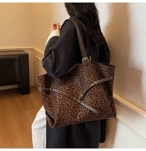Dettaglio della borsa tote leopardata retrò con cinturino in pelle marrone e fibbia