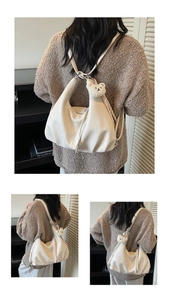 Detail view of cream Hobo bag with plush bear charm and checkered silk scarf accent