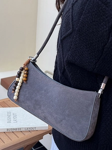 Gray suede hobo bag for women with decorative beaded tassel and curved silhouette