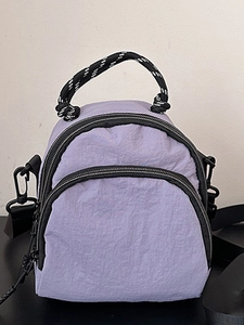 Light purple nylon shell backpack with multi-zipper compartments and woven stripe handle