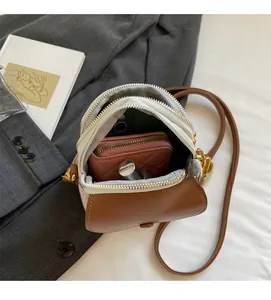 Vue de dessus d'un sac bandoulière marron spacieux montrant plusieurs poches et accessoires