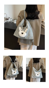 Detail of grey canvas hobo bag featuring 3D plush dog patch and wide shoulder strap