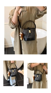 Close-up of color-block bucket bag with marble texture, gold hardware, and plush bear charm