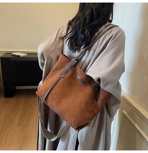 Detail of caramel suede tote bag with quilted pattern shown on a model in a modern interior