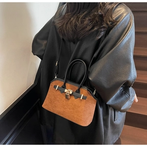 Détail du sac cabas vintage en daim marron avec anse en cuir noir et boucle métallique