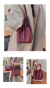 Detail of burgundy lychee grain leather bucket bag with inner pouch and shoulder strap