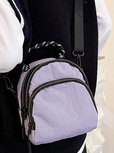 Minimalist lavender shell backpack with woven handle shown on model in side view