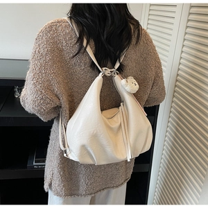 Cream hobo bag detail with long fringe zipper and cute plush bear charm on back