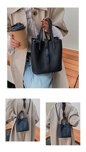 Close-up of black lychee grain leather bucket bag with silver metal ball buckle detail