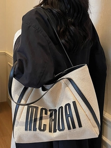 Grand sac fourre-tout en toile avec bordure en cuir et lettrage MCROAI sur le mannequin