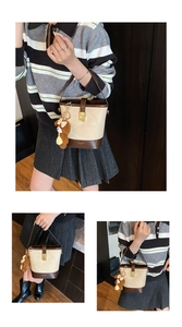 Close-up of contrast bucket bag with metallic lock and cute plush bear charm