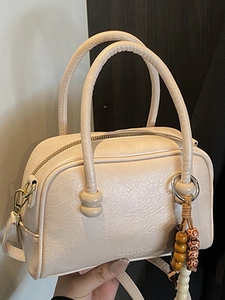 Sac à main Boston chic couleur crème en cuir PU texturé avec détail de pompon perlé