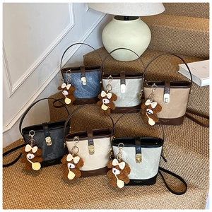 Macro shot of canvas bucket bags in six colors with leather base and bear charm decor