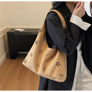 Détail du motif floral découpé au laser sur le sac à bandoulière en daim marron