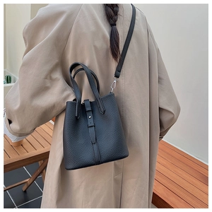 Detailed back view of a minimalist black pebbled leather bucket bag with silver hardware hooks