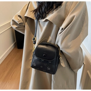 Détail du sac bandoulière noir avec gaufrage floral élan et garnitures dorées
