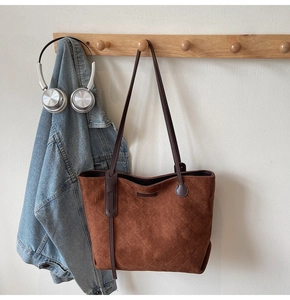 Detail of classic diamond-quilted stitching on a large brown matte faux suede tote bag