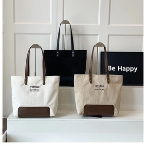 Tre borse tote in velluto a coste crema, nero e kaki con base in pelle e scritte decorative