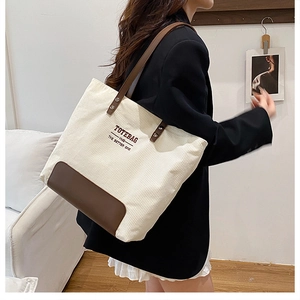 Dettaglio della trama in velluto a coste crema e fondo in pelle marrone della borsa tote