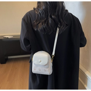 Vue détaillée du mini sac bandoulière beige avec motif cerf et boucle métallique