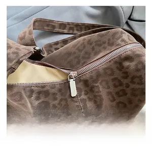 Detail showing smooth silver metal zipper and soft leopard print fabric texture