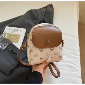 Détail du mini sac élégant en cuir crème avec finitions dorées et rabat marron