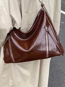 Brown high-gloss patent leather hobo tote bag with symmetrical vertical zipper detail