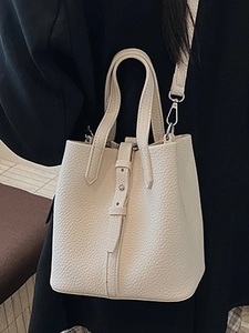 Chic beige lychee leather bucket bag with top handles and adjustable shoulder strap