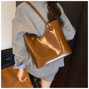 Detail van bruine glanzende shopper tas met olie-was textuur voor een stijlvolle look