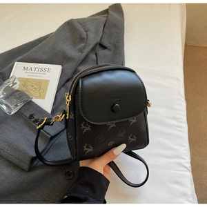Détail d'un mini sac noir à imprimés animaliers et texte FASHION gaufré sur le rabat