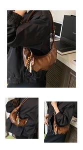 Détails du sac demi-lune en cuir marron avec une breloque décorative en perles de bois