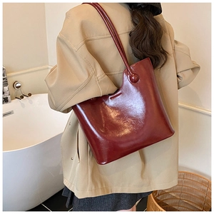 Detailweergave van bordeauxrode shopper met asymmetrische rand en glanzende look