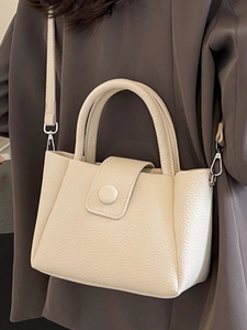 Chic beige lychee leather bucket bag for women featuring a round buckle and strap