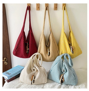 Detail view of five striped knitted tote bags with colorful wood bead charm accessories