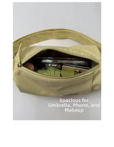 Top view of the spacious yellow crossbody bag interior holding an umbrella and phone
