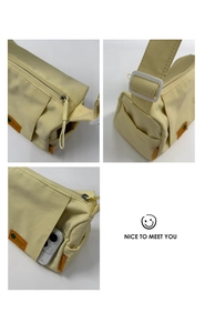 Detail view of the pale yellow nylon bag showing side pocket and durable wide shoulder strap